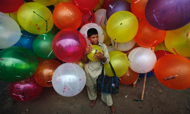 Một cậu bé bán bóng bay đang chờ khách tới mua bên ngoài một nhà thờ ở Karachi, Pakistan.