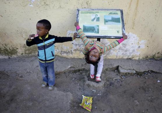 Trẻ em chơi cạnh bảng chỉ dẫn thông tin tại ngôi nhà cựu Tổng thống Nam Phi Nelson Mandela từ ở trong những năm 1940, tại thị trấn Alexandra.
