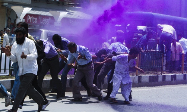 Các sát sử dụng vòi rồng phun nước màu để giải tán những người biểu tình đòi tăng lương ở Srinagar, Ấn Độ.