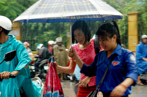 	Sinh viên tình nguyện ướt đẫm mưa vì hỗ trợ sĩ tử (Nguồn: Infonet)