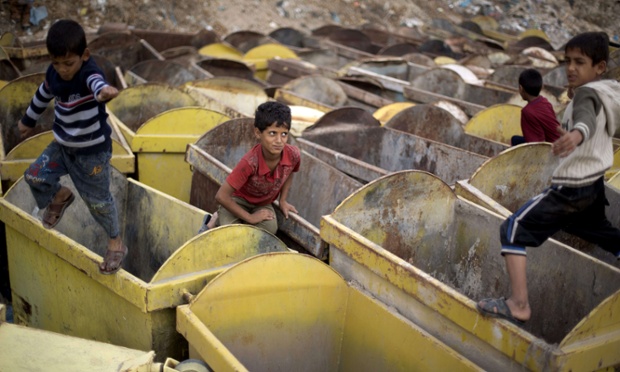 Trẻ em Palestin chơi trên những thùng rác gần một khu chợ tại thành phố Gaza.