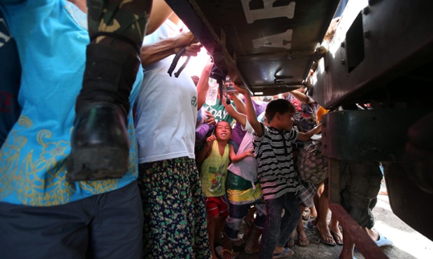 Người dân vây quanh một chiếc xe tải phân phát hàng hóa và thực phẩm cho nạn nhân của siêu bão Haiyan ở Tacloban, Philippines.