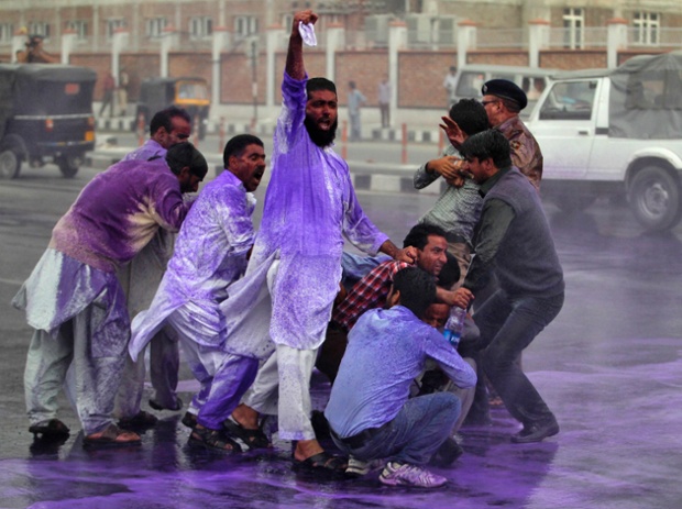 Cảnh sát chống bạo động dùng vòi rồng phun nước màu để giải tán những người biểu tình ở Srinagar, Ấn Độ.
