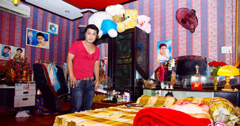 	Phòng ngủ của Lý Hùng được dán giấy hoa và trang trí bằng những tấm hình thời trai trẻ của anh.
