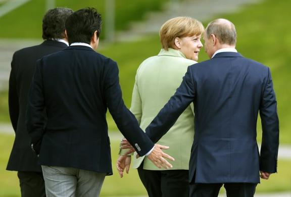 Thủ tướng Nhật Bản Shinzo Abe bắt tay Tổng thống Nga Vladimir Putin khi họ đi cùng Thủ tướng Đức Angela Merkel, sau khi  các nhà lãnh đại nhóm G8 chụp ảnh chung cùng nhau tại khu nghỉ dưỡng Lough Erne ở Enniskillen, Bắc Ireland.