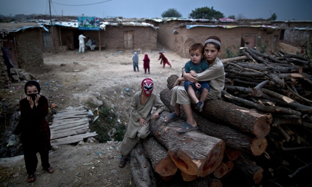Trẻ em tị nạn Afghanistan chơi trên một đống gỗ thông tại khu dân cư nghèo ở ngoại ô Islamabad, Pakistan.