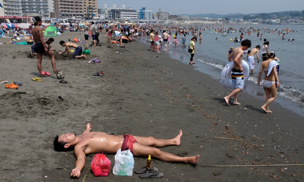 Một người đàn ông nằm tắm nắng trên bãi biển ở thành phố Fujisawa, tỉnh Kanagawa, Nhật Bản. Khu vực này đang trải qua đợt nắng nóng kỷ lục trong năm nay.
