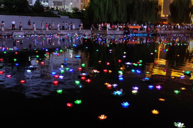 Mọi người ngắm đèn hoa sen được thả trên sông nhân dịp lễ Vu Lan ở Tế Nam thuộc tỉnh Sơn Đông, Trung Quốc.