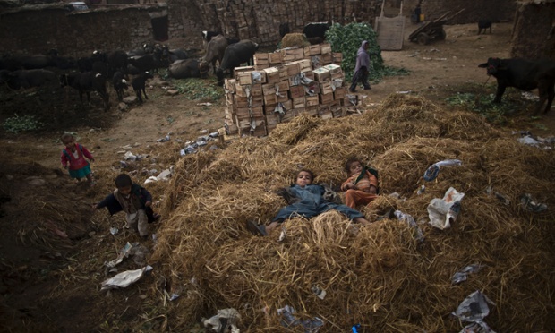 Trẻ em tị nạn người Afghanistan nằm trên một đống rơm ở Islamabad, Pakistan.