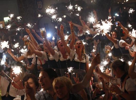 Các nhân viên phục vụ cầm pháo sáng để chào mừng buổi bế mạc lễ hội bia Oktoberfest ở Munich, Đức.