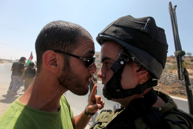 Một người Palestin và binh sĩ Israel đối mặt nhau trong cuộc biểu tình phản đối khu định cư Efrata của Israel ở Bờ Tây.