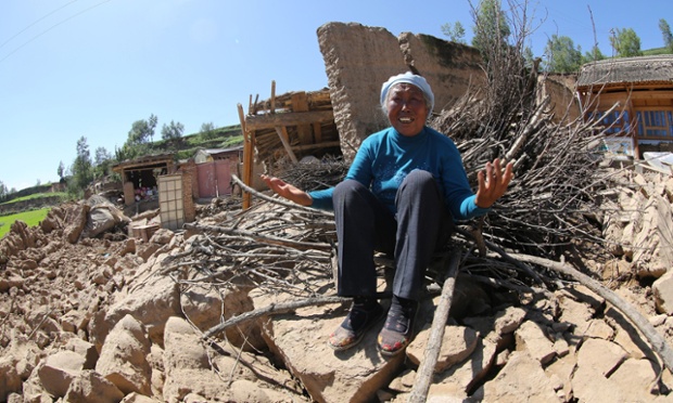Một người dân than khóc trên ngôi nhà đổ nát do động đất ở thành phố Định Tây thuộc tỉnh Cam Túc, Trung Quốc.