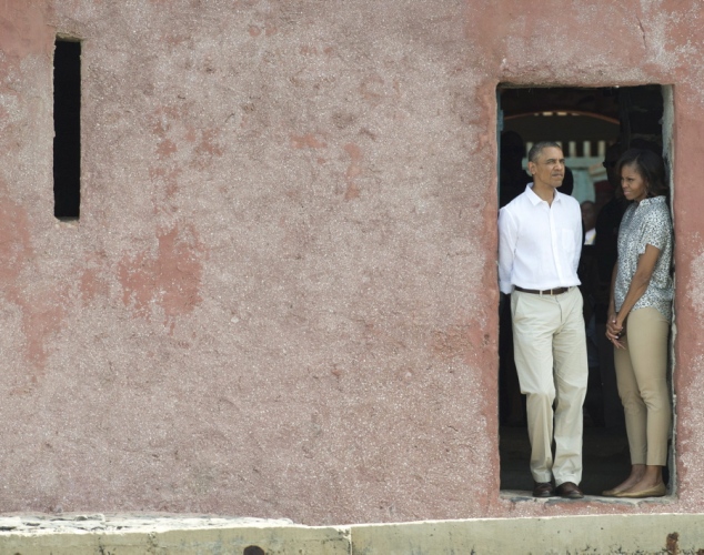 Tổng thống Mỹ Barack Obama và phu nhân nhìn ra ngoài từ cửa nhà tù Maison des Esclaves nằm trên đảo Goree thuộc Senegal từng là nơi giam giữ nô lệ châu Phi.