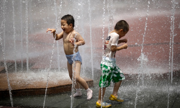 Các cậu bé tắm mát trong đài phun nước tại thành phố Thượng Hải, Trung Quốc, khi nhiệt độ ở đây tăng lên tới 40 độ C.