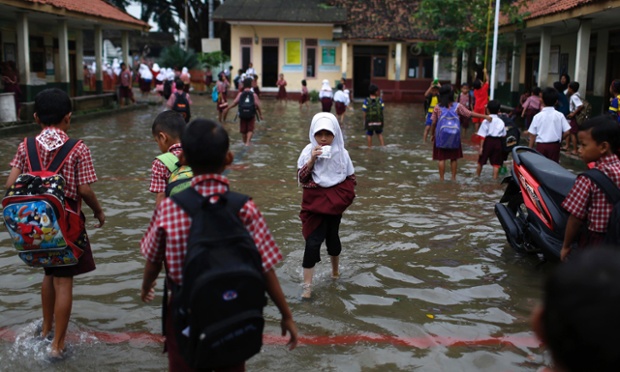 Học sinh lội trên sân ngập nước trong trường Tiểu học Lopang Domba ở Serang, Indonesia.