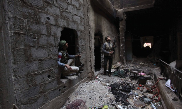 Các chiến binh phiến quân trong một tòa nhà nhìn lên bầu trời sau khi nghe thấy tiếng máy bay chiến đấu MiG ở Deir al-Zor, Syria.