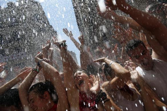 Mọi người bị đổ nước từ ban công của các ngôi nhà hai bên đường phố trong lễ hội San Fermin ở Pamplona, Tây Ban Nha.