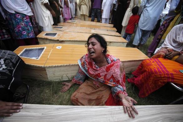 Một phụ nữ than khóc cạnh quan tài của em trai thiệt mạng trong vụ đánh bom tự sát tại một nhà thờ Cơ đốc giái ở Peshawar, Pakistan.