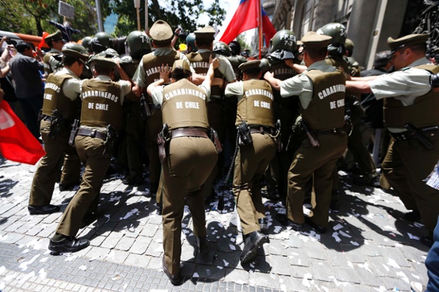 Cảnh sát chống bạo động đẩy lui người biểu tình đòi tăng lương ở thành phố Santiago, Chile.