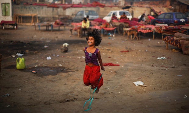 Bé gái chơi cạnh một khu ở tạm tại thành phố Delhi, Ấn Độ.