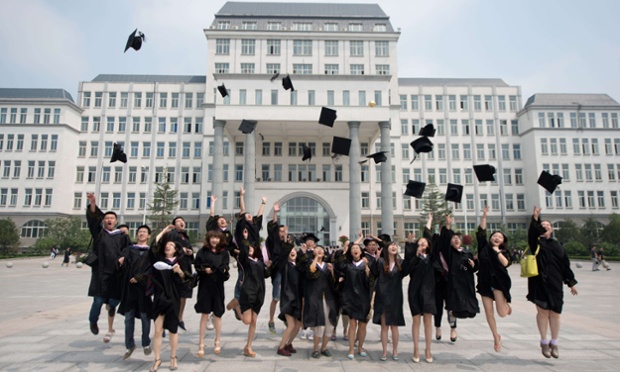 Các sinh viên tung mũ lên cao khi chụp ảnh trong lễ tốt nghiệp tại trường đại học quốc tế Kade ở Bắc Kinh, Trung Quốc.