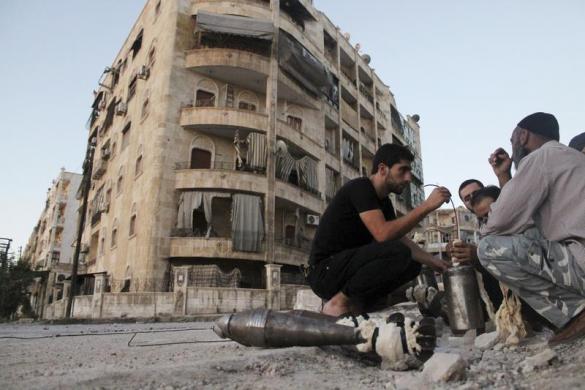 Các chiến binh của lực lượng Syria tự do đang chuẩn bị rocket tự chế ngay trên đường phố ở Aleppo, Syria.