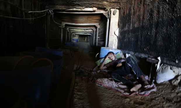 Một người đàn ông nằm nghỉ dưới đường hầm buôn lậu thực phẩm nối Ai Cập với Dải Gaza.