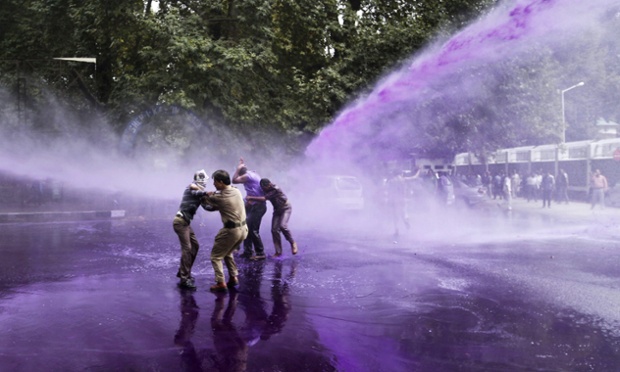 Cảnh sát chống bạo động dùng vòi rồng phun nước màu để giải tán người biểu tình ở Srinagar, Kashmir, Ấn Độ.
