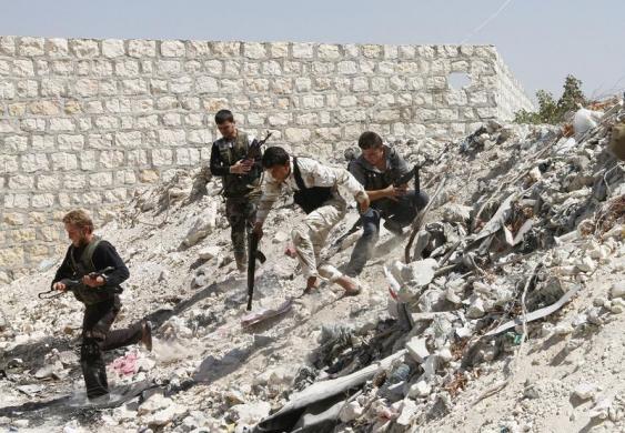 Các chiến binh của lực lượng phiến quân chạy tìm nơi ẩn nấp trong một ngôi làng ở Aleppo, Syria.