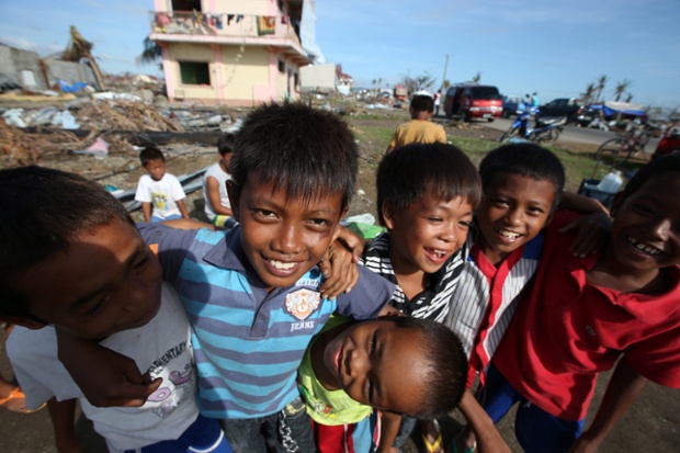 Trẻ em cười đùa trong khi đứng chờ nhận thực phẩm cứu trợ sau siêu bão Haiyan ở Tacloban, Philippines.