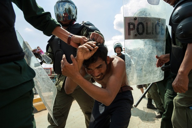 Cảnh sát chống bạo động bắt giữ một người biểu tình ở thủ đô Phnom Penh, Campuchia.
