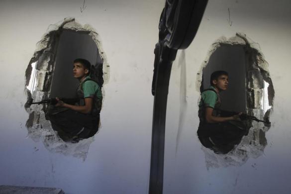 Chiến binh 15 tuổi của lực lượng quân đội Syria tự do chiến đấu trong một ngôi nhà ở Aleppo, Syria.