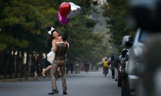 Chú rể nhấc bổng cô dâu trên đường phố ở Bắc Kinh, Trung Quốc.