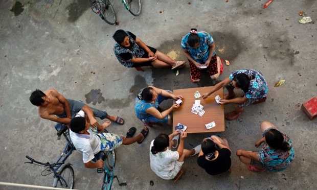 Các công nhân nhập cư ngồi chơi bài sau một ngày làm việc mệt nhọc tại công trường xây dựng một khu chung cư ở Thượng Hải, Trung Quốc.
