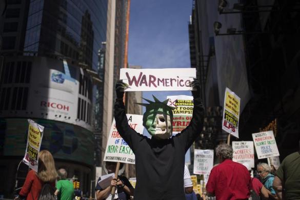Mọi người tham gia biểu tình phản đối cuộc tấn công quân sự vào Syria tại quảng trường Thời đại ở New York, Mỹ.
