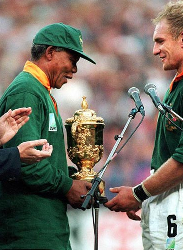 	Tổng thống Nelson Mandela mặc đồng phục của đội tuyển Nam Phi tại	Johannesburg sau khi Nam Phi chiến thắng trận chung kết bóng bầu dục	World Cup năm 1995.