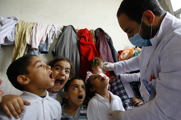 Trẻ em Syria đứng xếp hàng để chờ uống vắcxin phòng bại liệt trong một trại tị nạn ở Sidon, Li Băng.