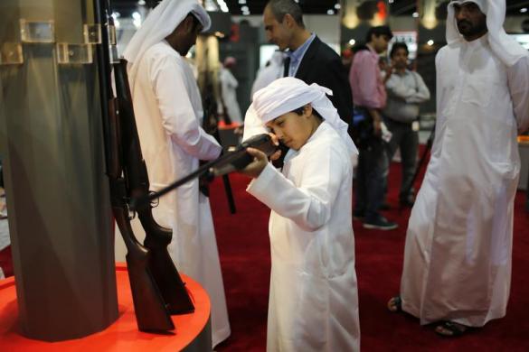 Một cậu bé kiểm tra súng tại Triểm lãm súng săn quốc tế ở Abu Dhabi.
