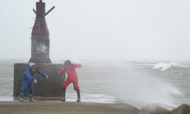 Một cặp đôi đang cố gắng giữ thăng bằng trước gió lớn và mưa do bão tại cảng Taito ở tỉnh Chiba, Nhật Bản.