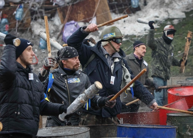 Người biểu tình gõ vỏ những thùng dầu cạnh rào chắn trên quảng trường Độc lập ở Kiev, Ukraine.