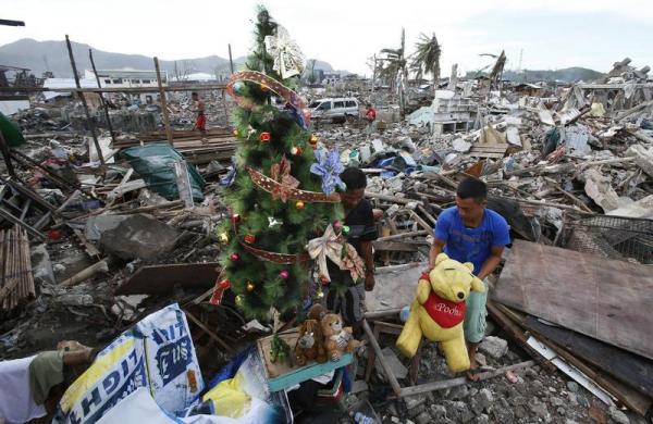 Người dân trang trí cây thông Giáng sinh giữa những ngôi nhà đổ nát do siêu bão Haiyan ở Tacloban, Philippines.