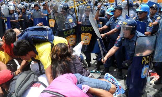 Cảnh sát chống bạo động đánh người biểu tình chống chính phủ khi họ cố gắng tuần hành trước tòa nhà Quốc hội Manila, Philippines.