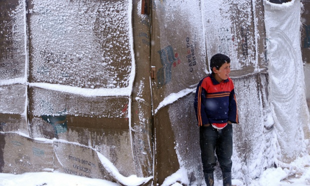 Một cậu bé tị nạn người Syria đứng dưới mưa tuyết bên ngoài lều tại thung lũng Bekaa, Li Băng.