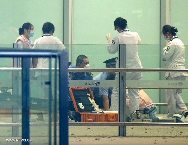 Các điều tra viên và nhân viên y tế tại hiện trường vụ đánh bom tự sát ở sân bay quốc tế Bắc Kinh chiều tối nay, 20/7