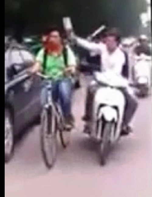 Hành động đạp chai vào đầu người đi đường của hai thanh niên (Ảnh cắt từ clip)