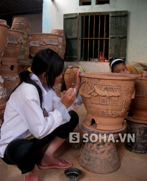 Vẽ hoa văn cho bình hoa.