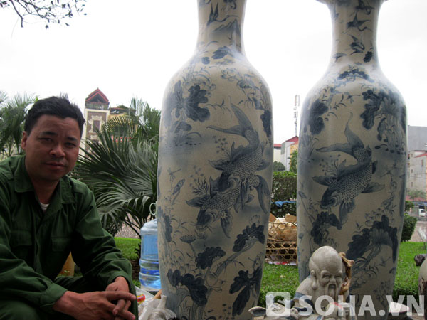 Chủ của dãy lộc bình và gốm sứ bày bán bên vỉa hè đường Láng (Đống Đa, Hà Nội) là anh Trần Văn Oang, 39 tuổi, một người làm gốm của làng nghề Bát Tràng (Đông Anh, Hà Nội).