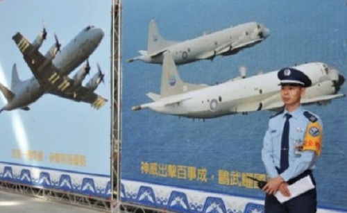 Một binh sĩ Đài Loan đứng cạnh tấm poster in hình máy bay tuần tra săn ngầm P-3C
