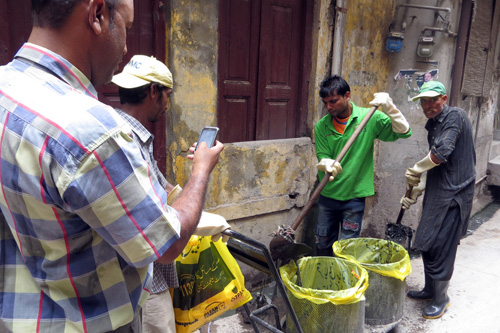  	Người giám sát Mohammad Saleem Taqi đang chụp ảnh các công nhân vệ sinh dọn sạch cống. Chính phủ cần chụp ảnh để định vị lên bản đồ, theo dõi các nỗ lực ngăn ngừa bệnh sốt xuất huyết
