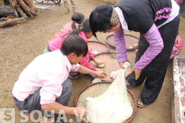 Những chàng thanh niên và các cô gái thực hiện công việc vắt bánh.